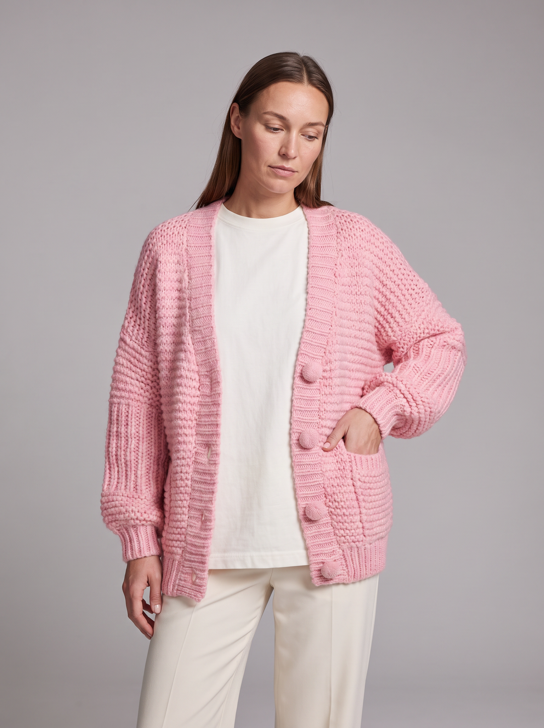 Women's pink chunky knit cardigan with buttons, long sleeves and patch pockets