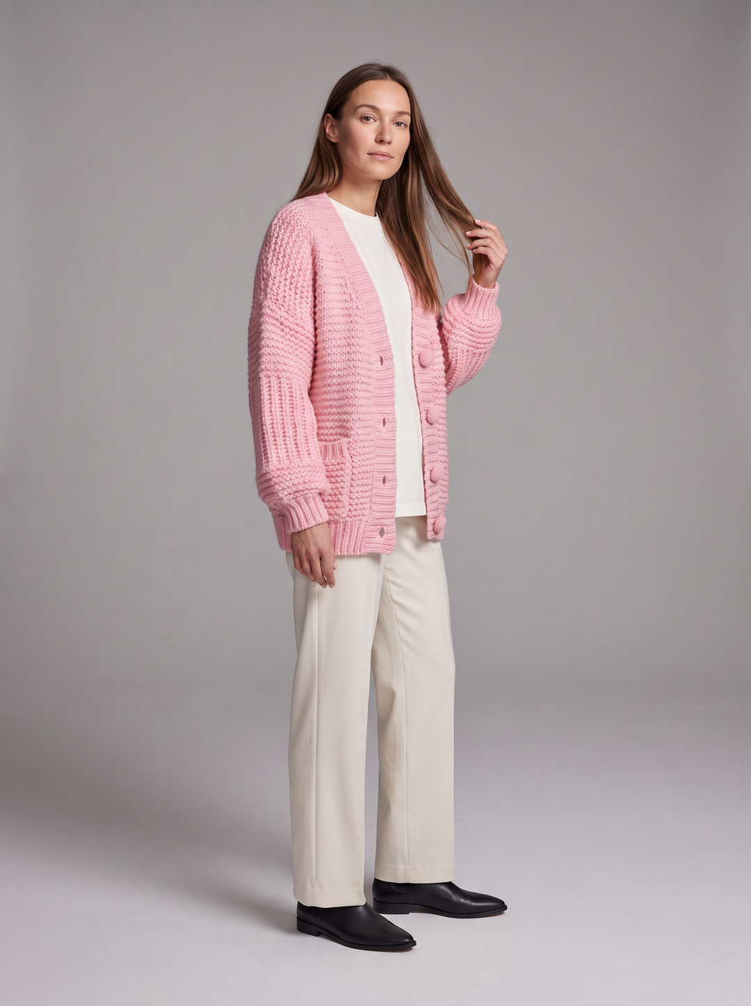Women's pink chunky knit cardigan with buttons, long sleeves and patch pockets