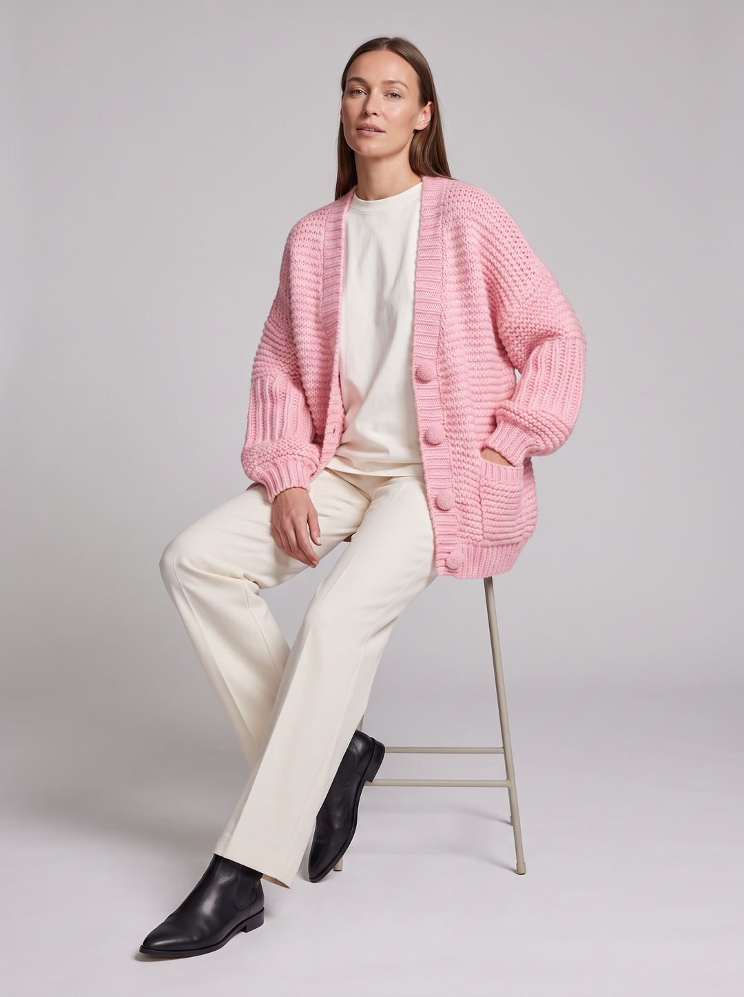 Women's pink chunky knit cardigan with buttons, long sleeves and patch pockets