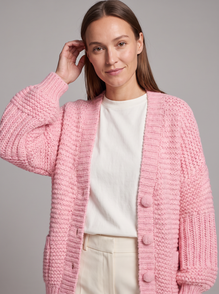 Women's pink chunky knit cardigan with buttons, long sleeves and patch pockets