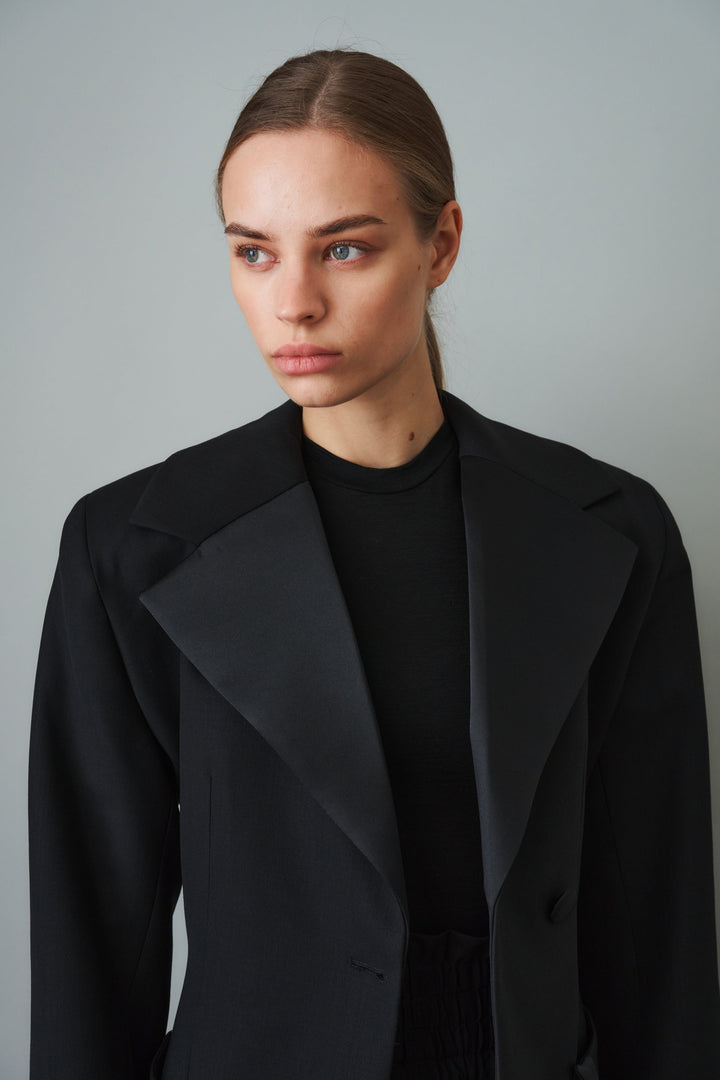 Women's black sculpted blazer with notched lapels and flap pockets