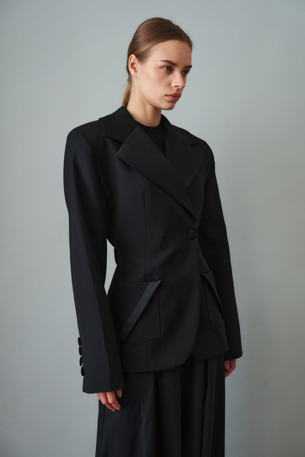 Women's black sculpted blazer with notched lapels and flap pockets