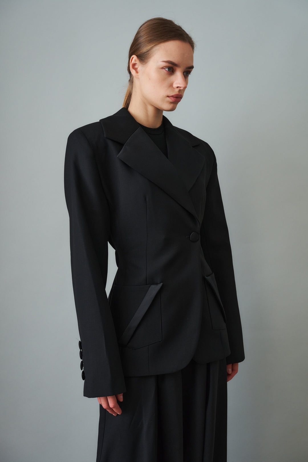 Women's black sculpted blazer with notched lapels and flap pockets