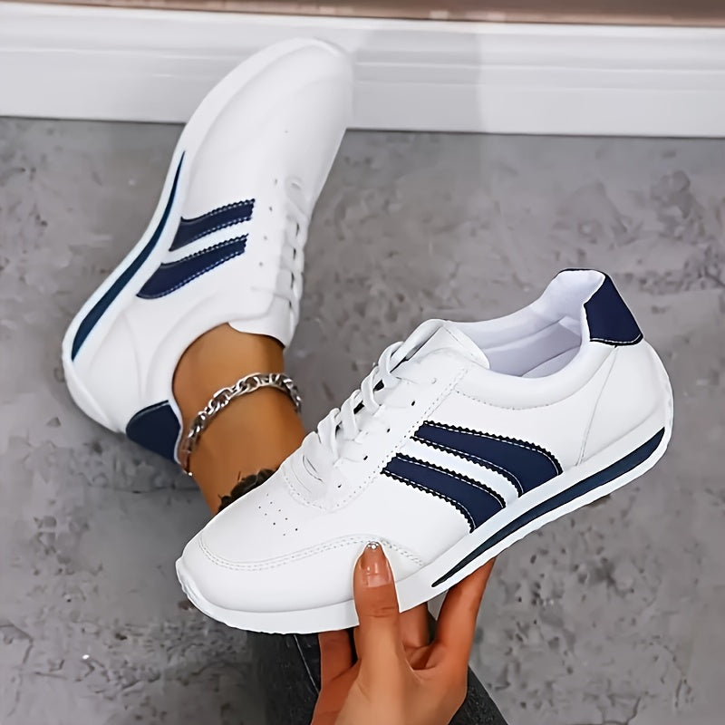 White women's lace-up sneakers with navy side stripes and round toes