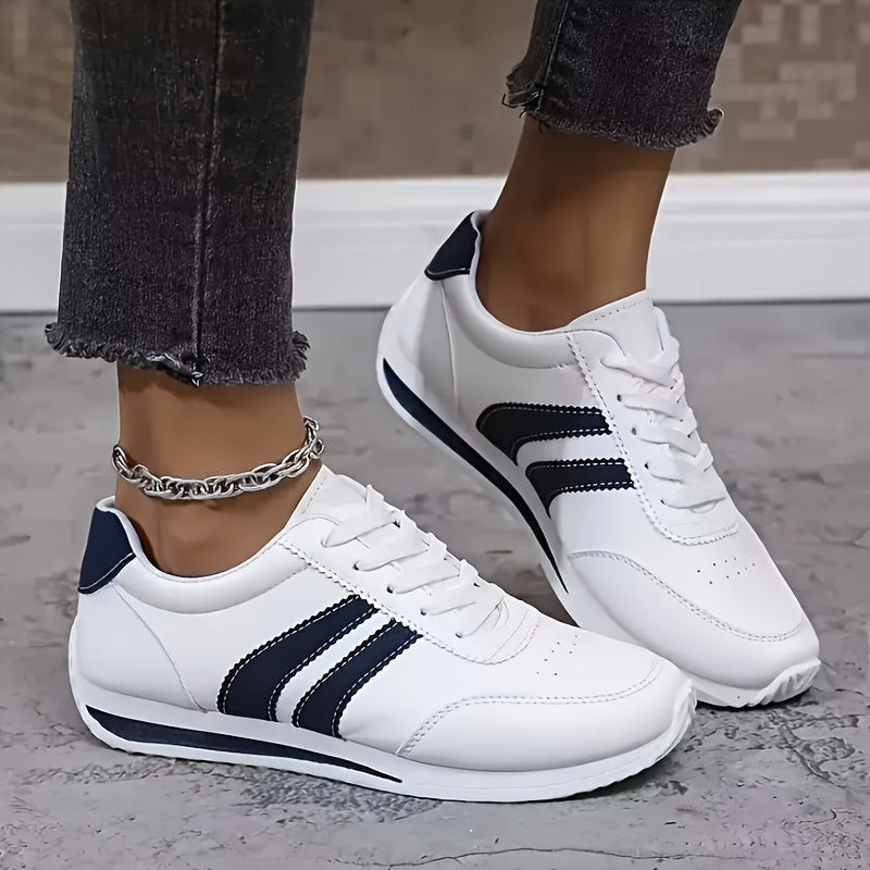 White women's lace-up sneakers with navy side stripes and round toes