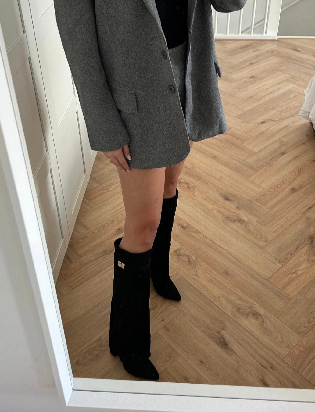 Black women's knee-high boots with pointed toes, low heels and buckle detail