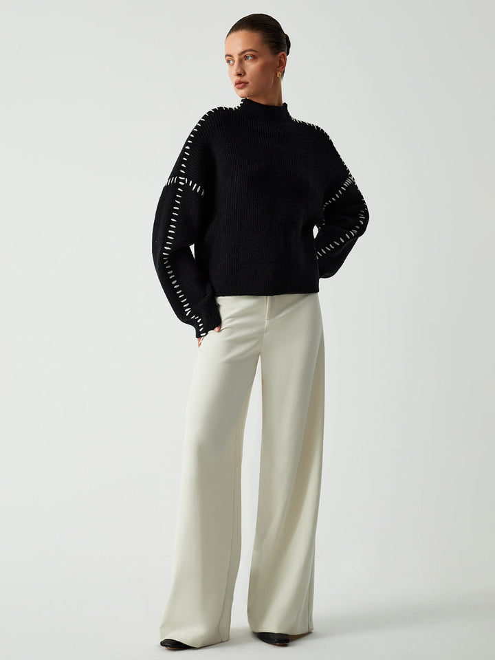 Women's black oversized knit sweater with contrast stitch seams and mock neck