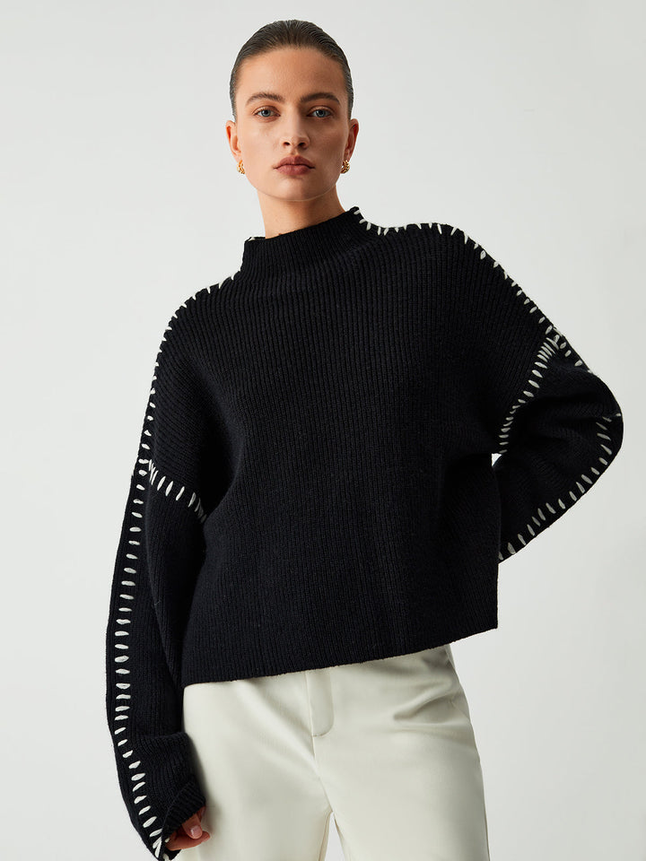 Women's black oversized knit sweater with contrast stitch seams and mock neck
