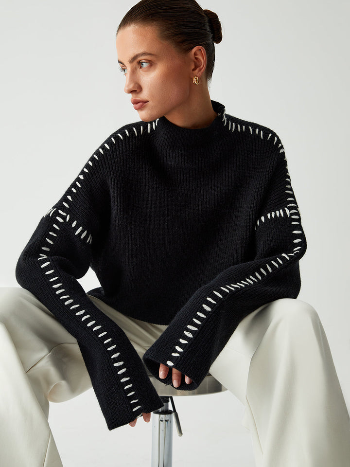 Women's black oversized knit sweater with contrast stitch seams and mock neck