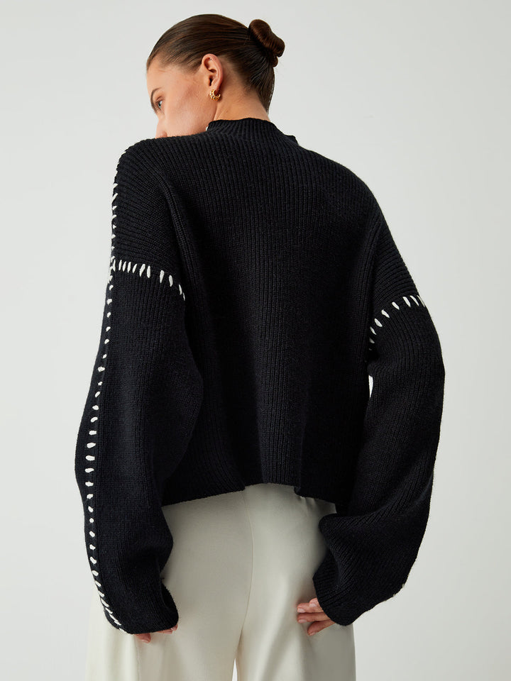 Women's black oversized knit sweater with contrast stitch seams and mock neck
