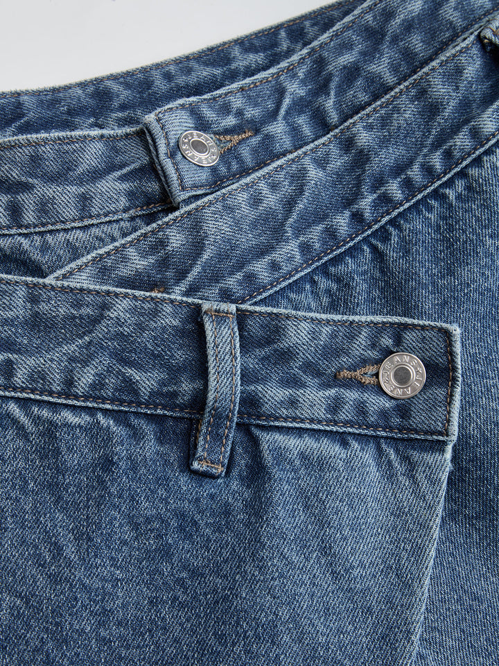 Women's blue wide-leg jeans with cross-front button waistband and utility pocket
