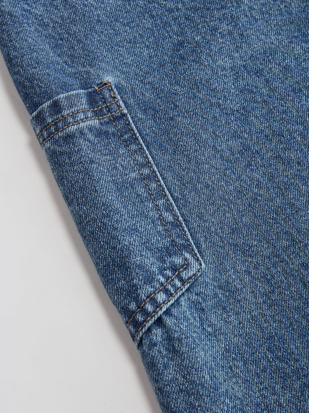 Women's blue wide-leg jeans with cross-front button waistband and utility pocket