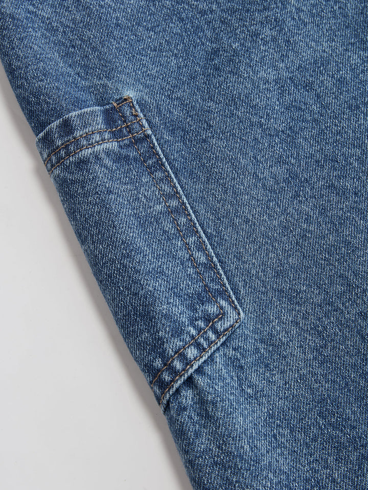 Women's blue wide-leg jeans with cross-front button waistband and utility pocket