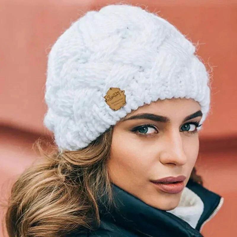Women's cable knit beanie hat with rolled cuff and front patch