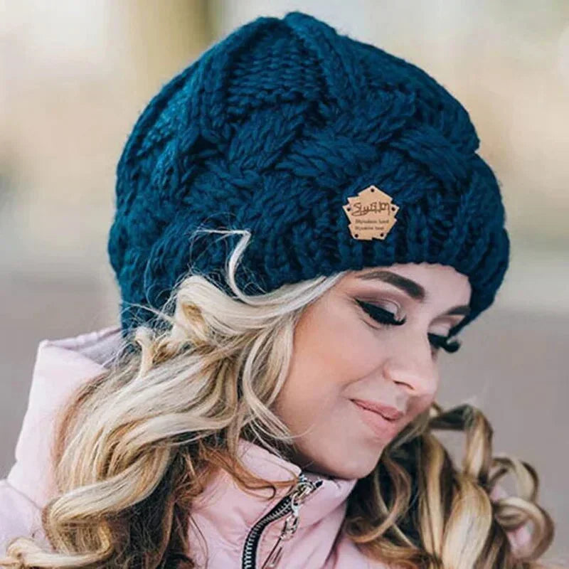 Women's cable knit beanie hat with rolled cuff and front patch