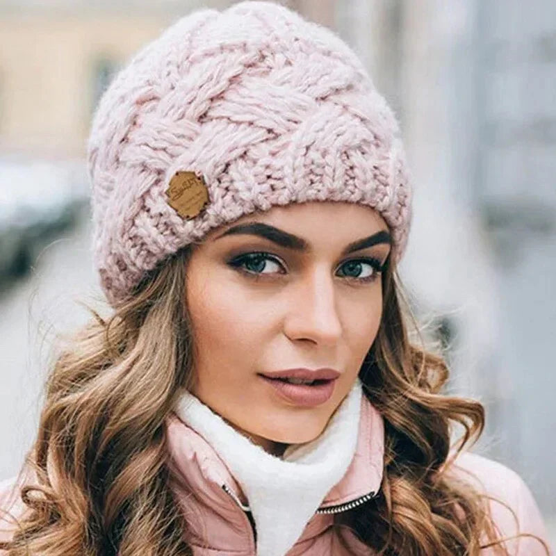 Women's cable knit beanie hat with rolled cuff and front patch