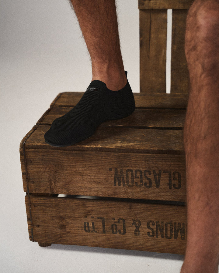 Knit slip-on shoes with round toes, pull tabs and flat black soles