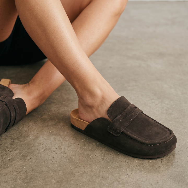 Women's brown flat loafer mule clogs with penny strap and rounded moc toe