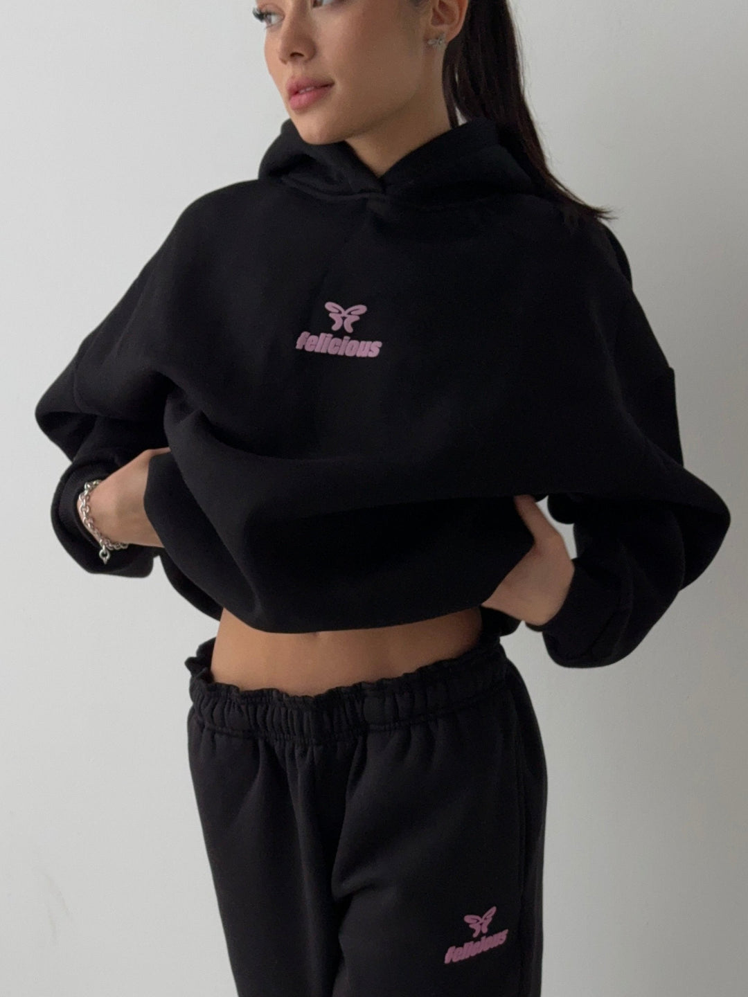 Women's black hooded sweatshirt with pink logo and ribbed trims