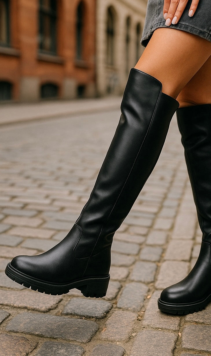 Black women's knee-high boots with round toes, side zippers, low heels and lug soles