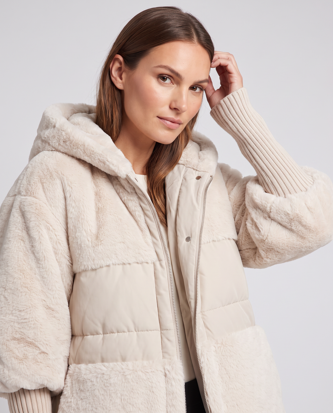 Women's hooded faux fur jacket with quilted panels and front pockets