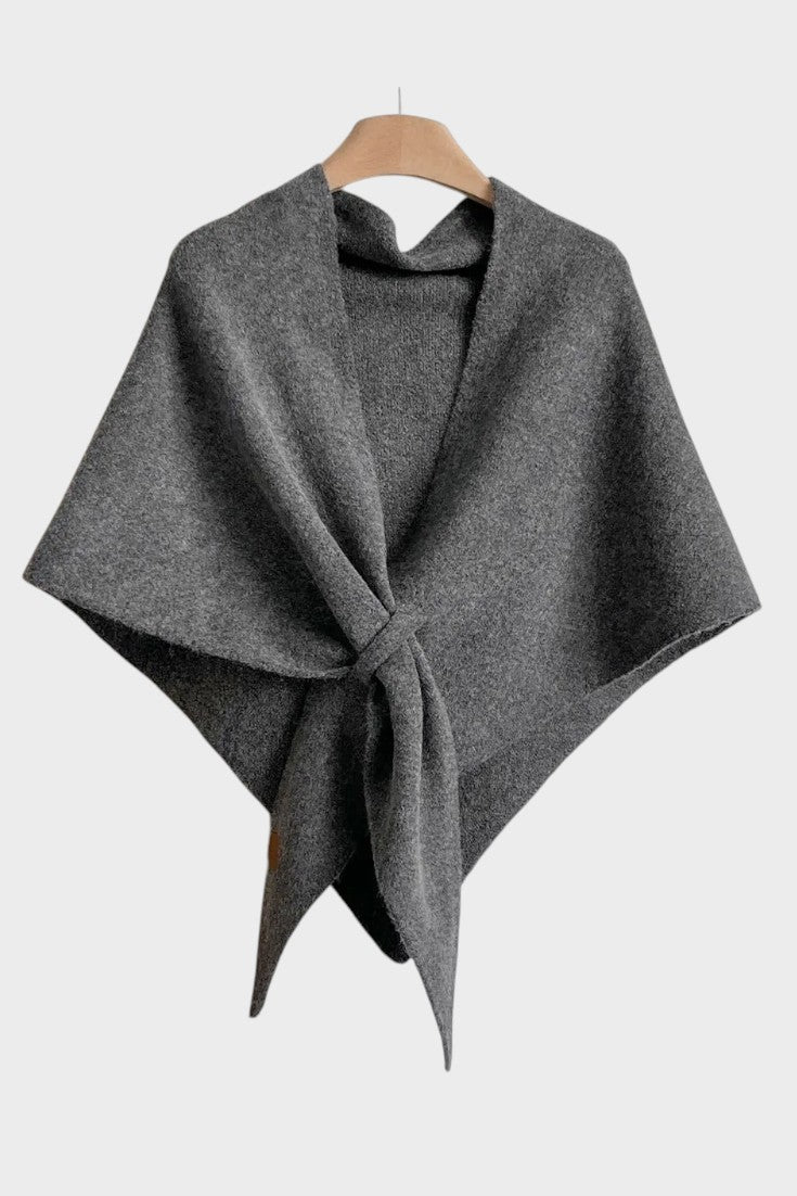Knitted triangle scarf draped over the shoulders with a tie front
