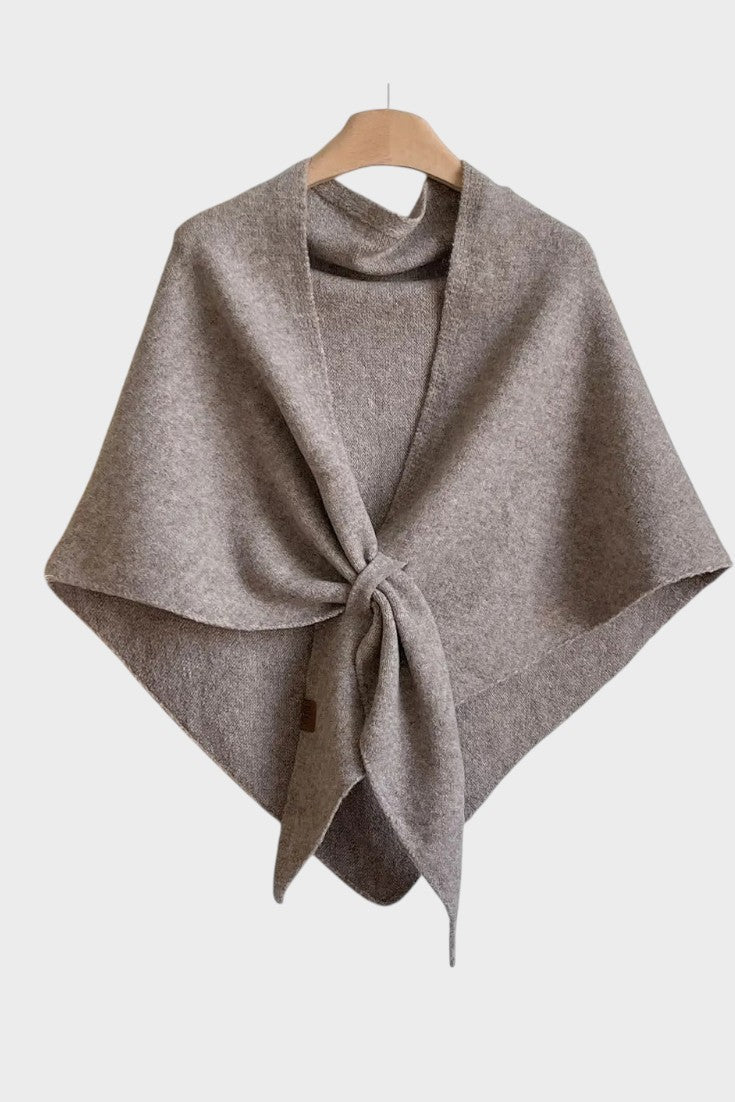 Knitted triangle scarf draped over the shoulders with a tie front