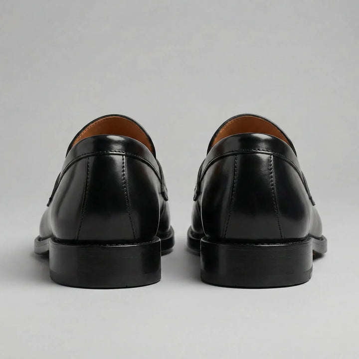 Black glossy penny loafers with moc toes and low block heels