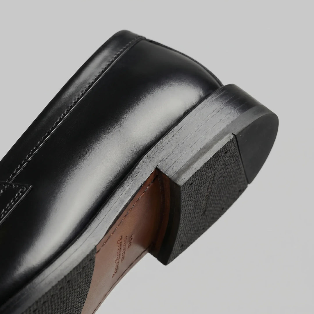Black glossy penny loafers with moc toes and low block heels