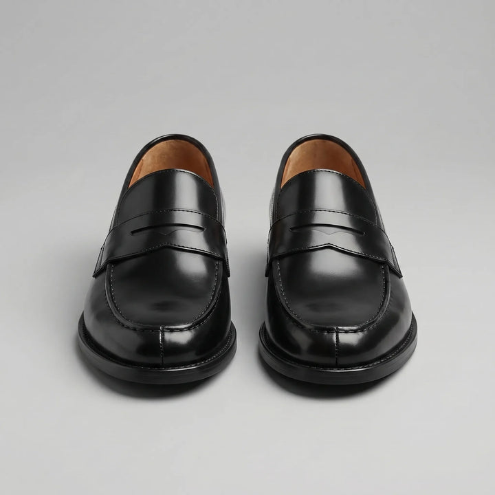 Black glossy penny loafers with moc toes and low block heels
