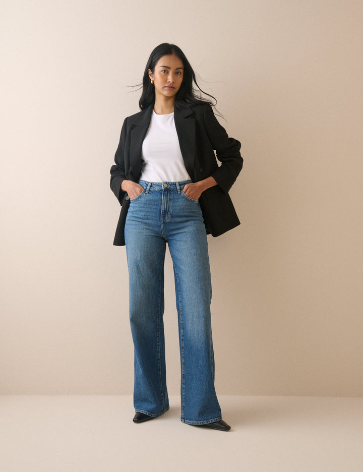 Women's mid-blue high rise wide leg jeans with full-length hems