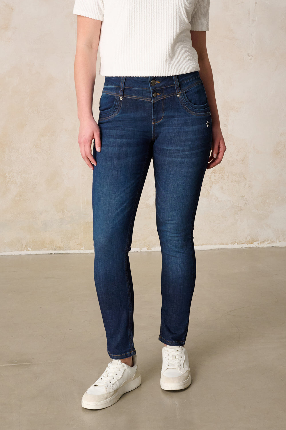 Women's dark blue slim fit jeans with mid-rise waist and button fly