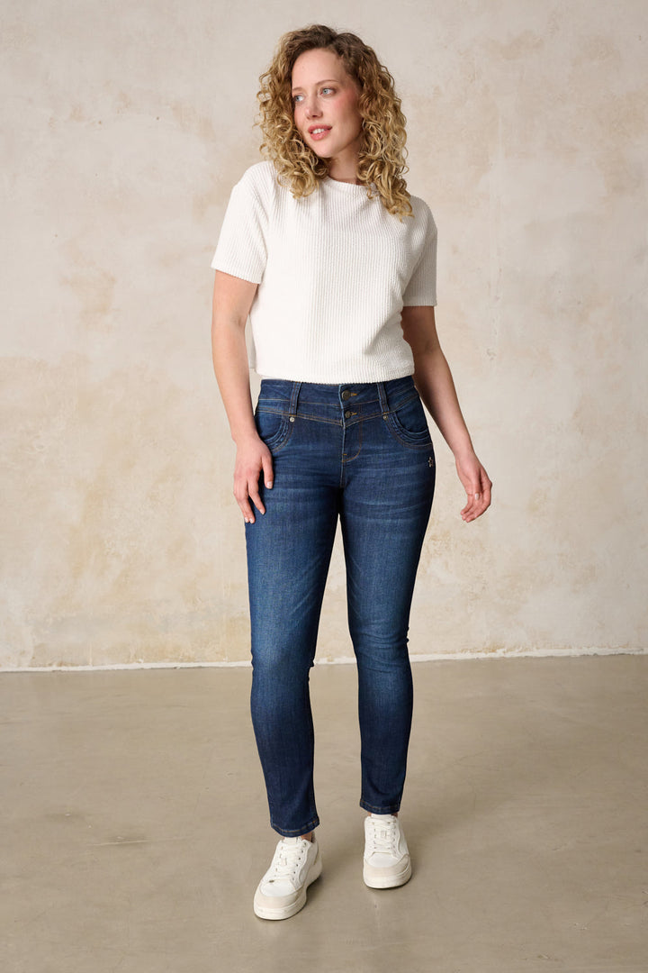 Women's dark blue slim fit jeans with mid-rise waist and button fly