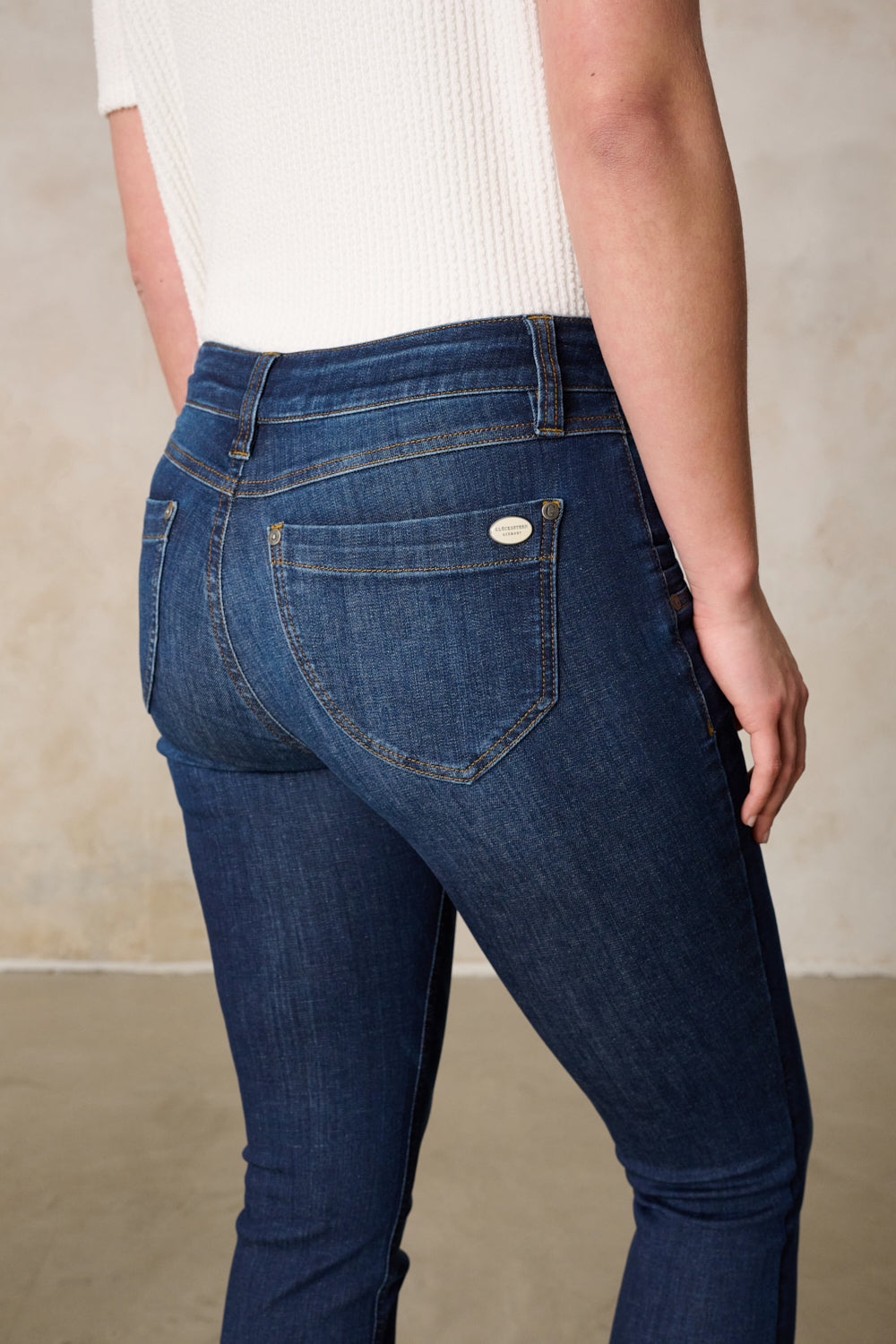 Women's dark blue slim fit jeans with mid-rise waist and button fly