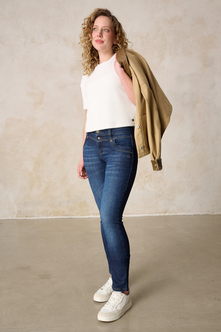 Women's dark blue slim fit jeans with mid-rise waist and button fly