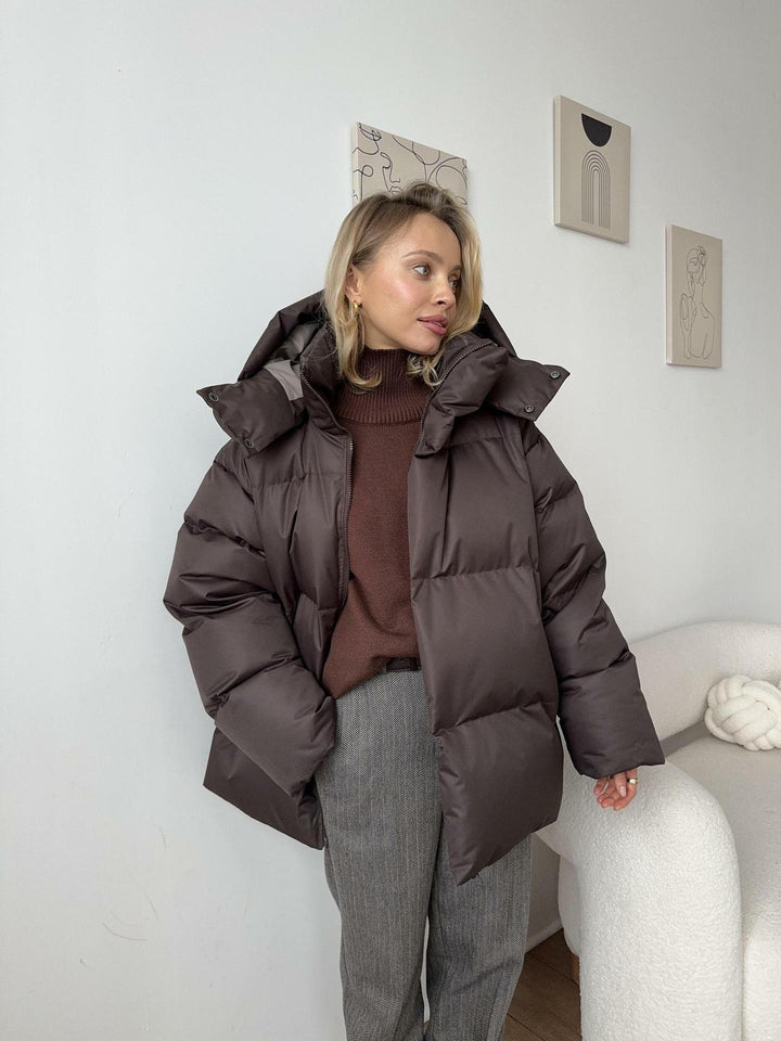 Women's oversized hooded puffer jacket with quilted panels and zip front