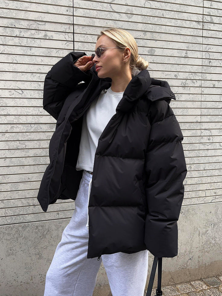 Women's oversized hooded puffer jacket with quilted panels and zip front