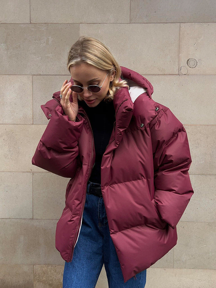 Women's oversized hooded puffer jacket with quilted panels and zip front