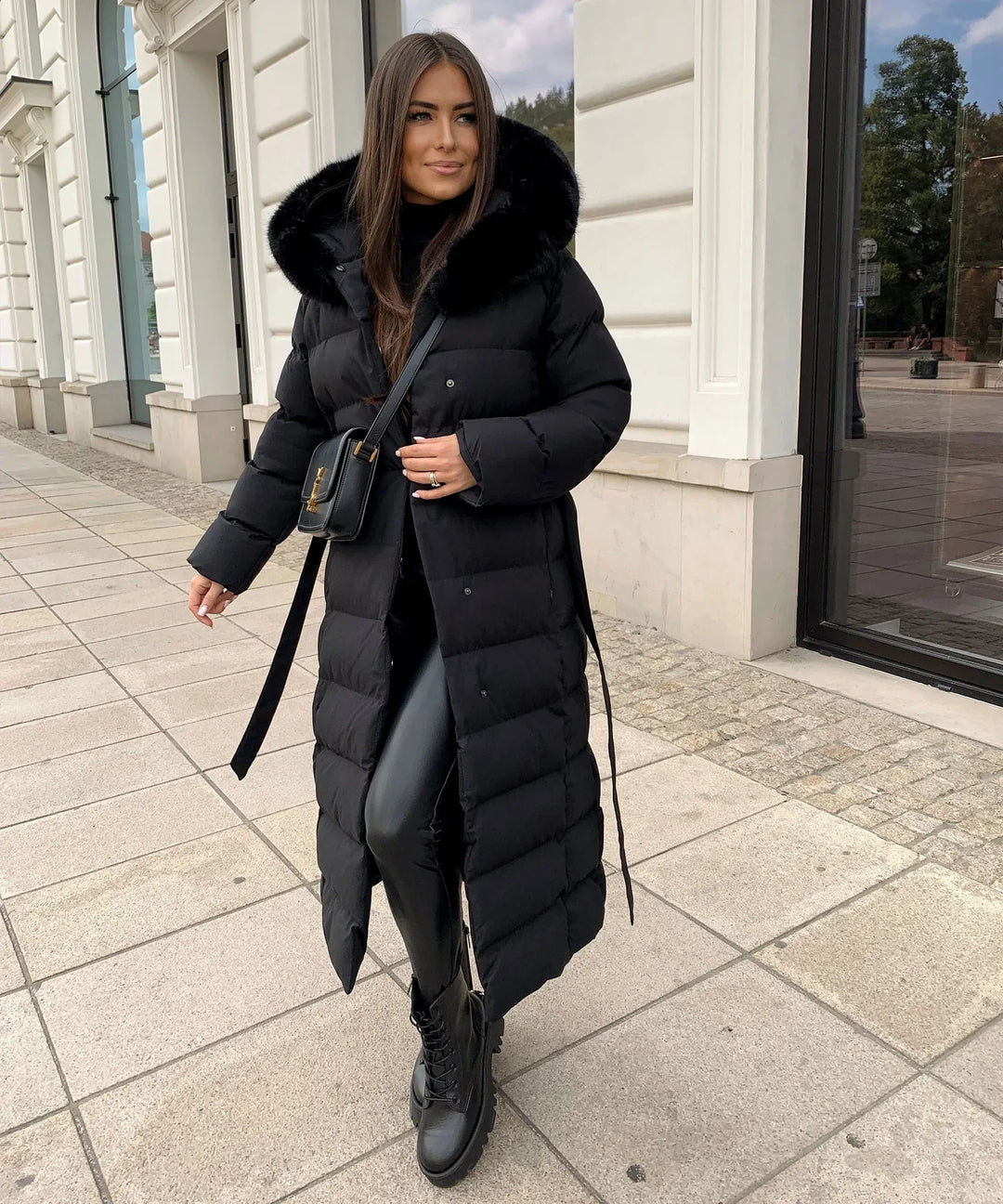 Women's black quilted puffer coat with hood, belt and long calf-length cut