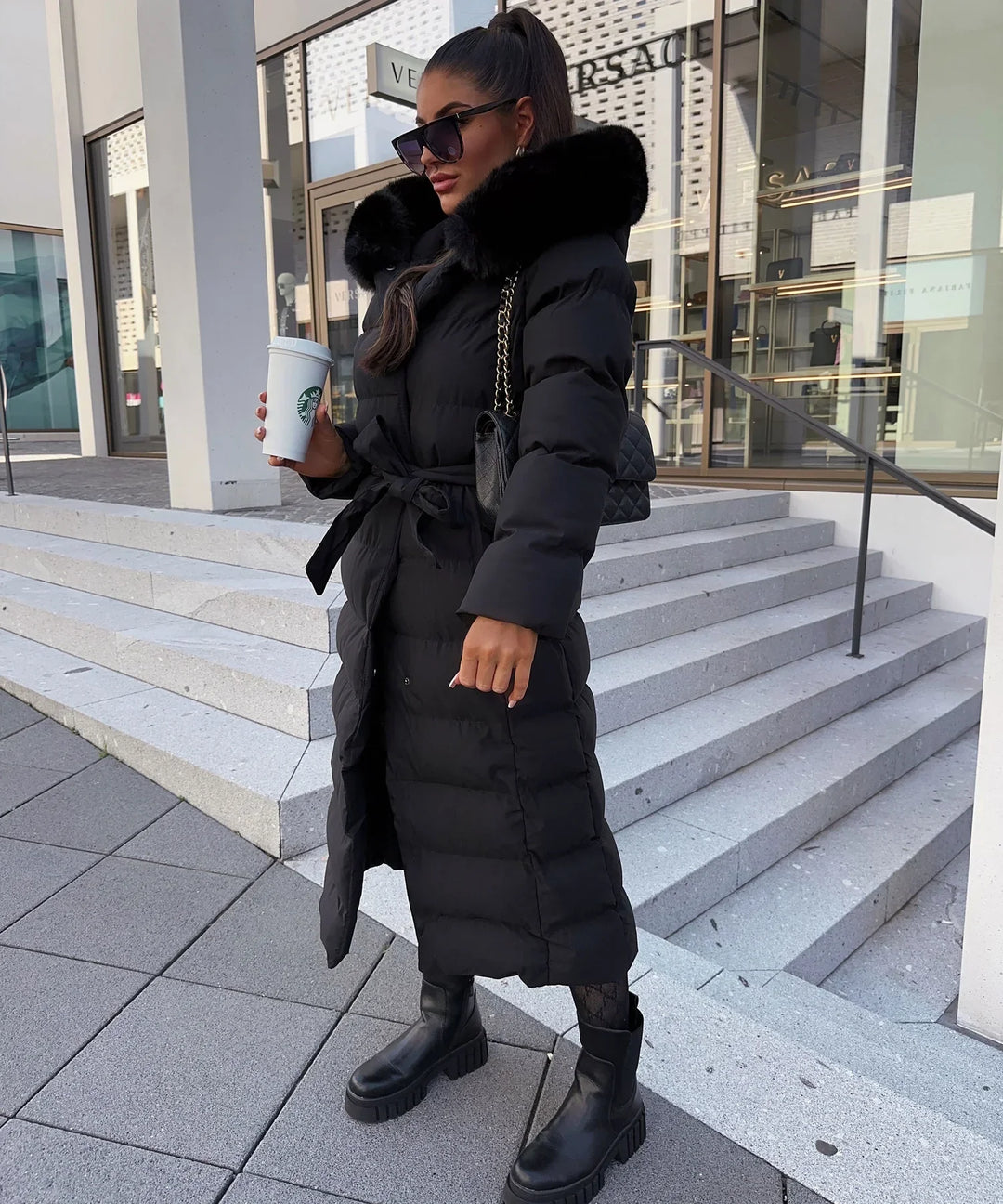 Women's black quilted puffer coat with hood, belt and long calf-length cut