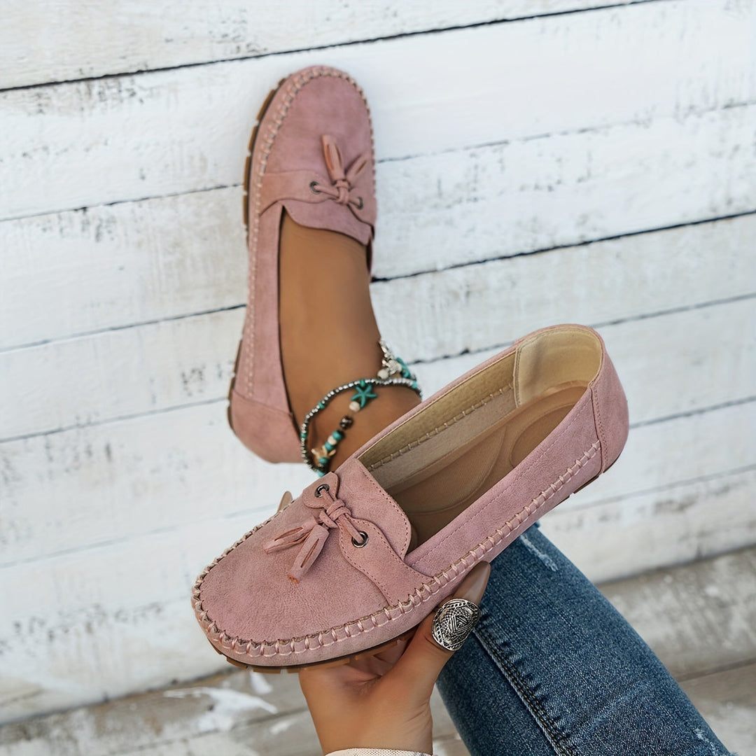 Women's slip-on tassel loafers with moccasin stitching and flat textured soles
