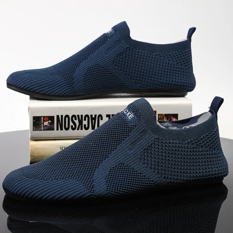 Knit slip-on shoes with round toes, pull tabs and flat black soles