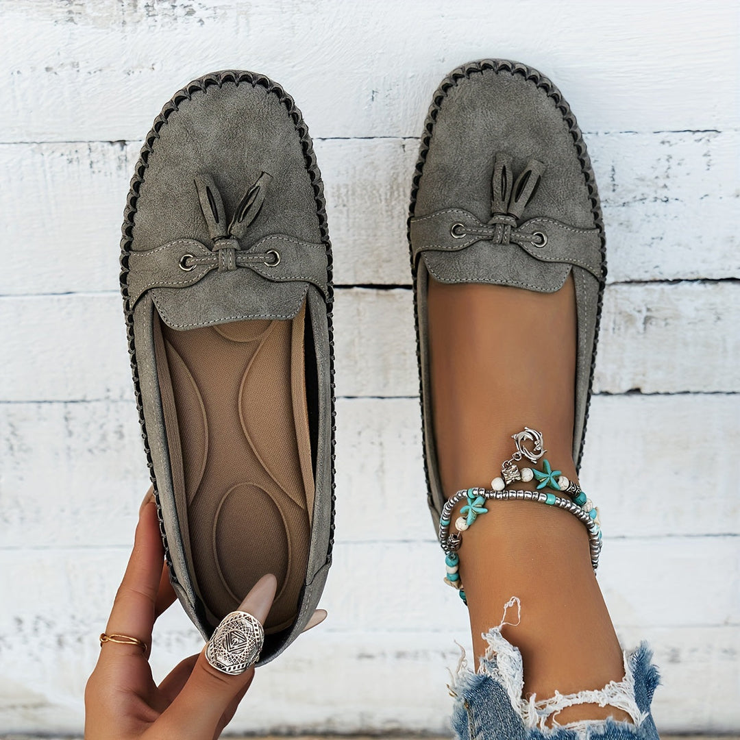 Women's slip-on tassel loafers with moccasin stitching and flat textured soles