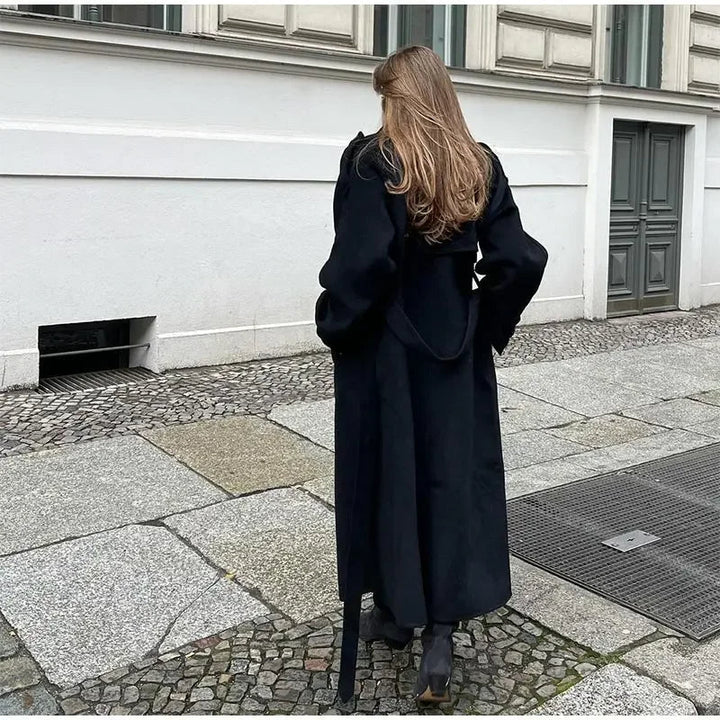 Women's black long double-breasted trench coat with lapels and waist belt