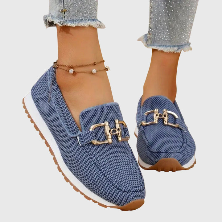 Women's textured slip-on sneakers with metallic buckle detail and flat ridged soles