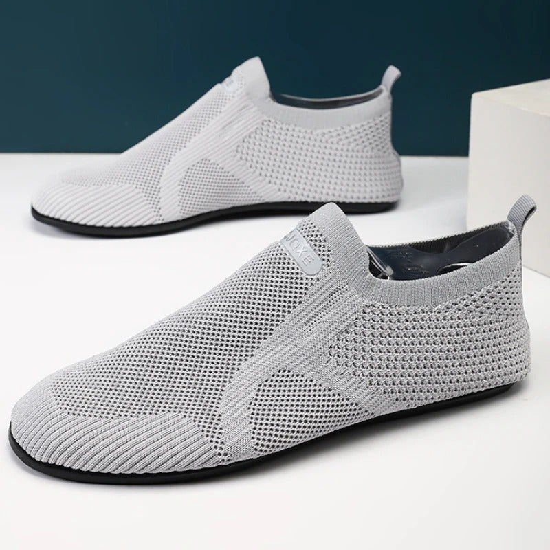 Knit slip-on shoes with round toes, pull tabs and flat black soles