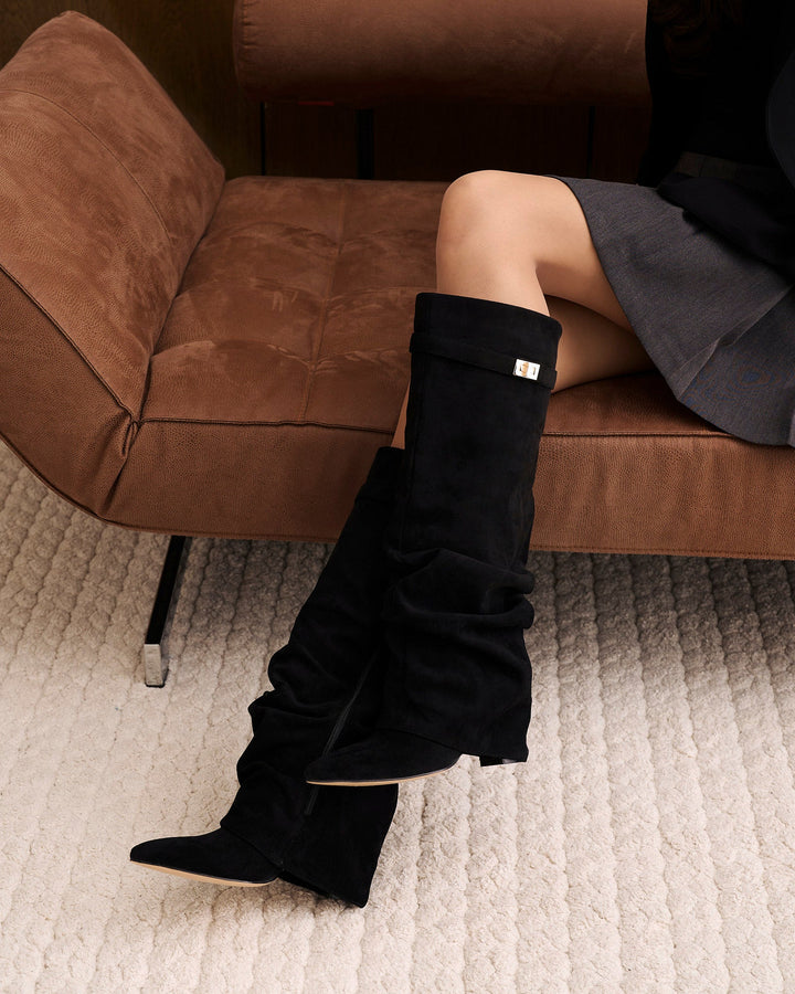 Black women's slouchy knee-high boots with pointed toes and buckle straps