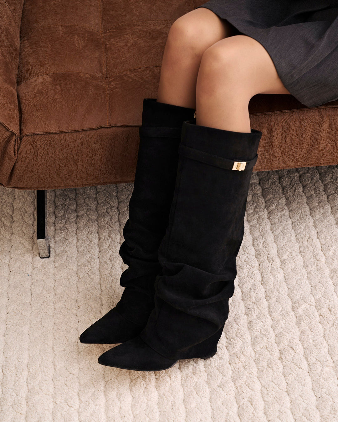Black women's slouchy knee-high boots with pointed toes and buckle straps