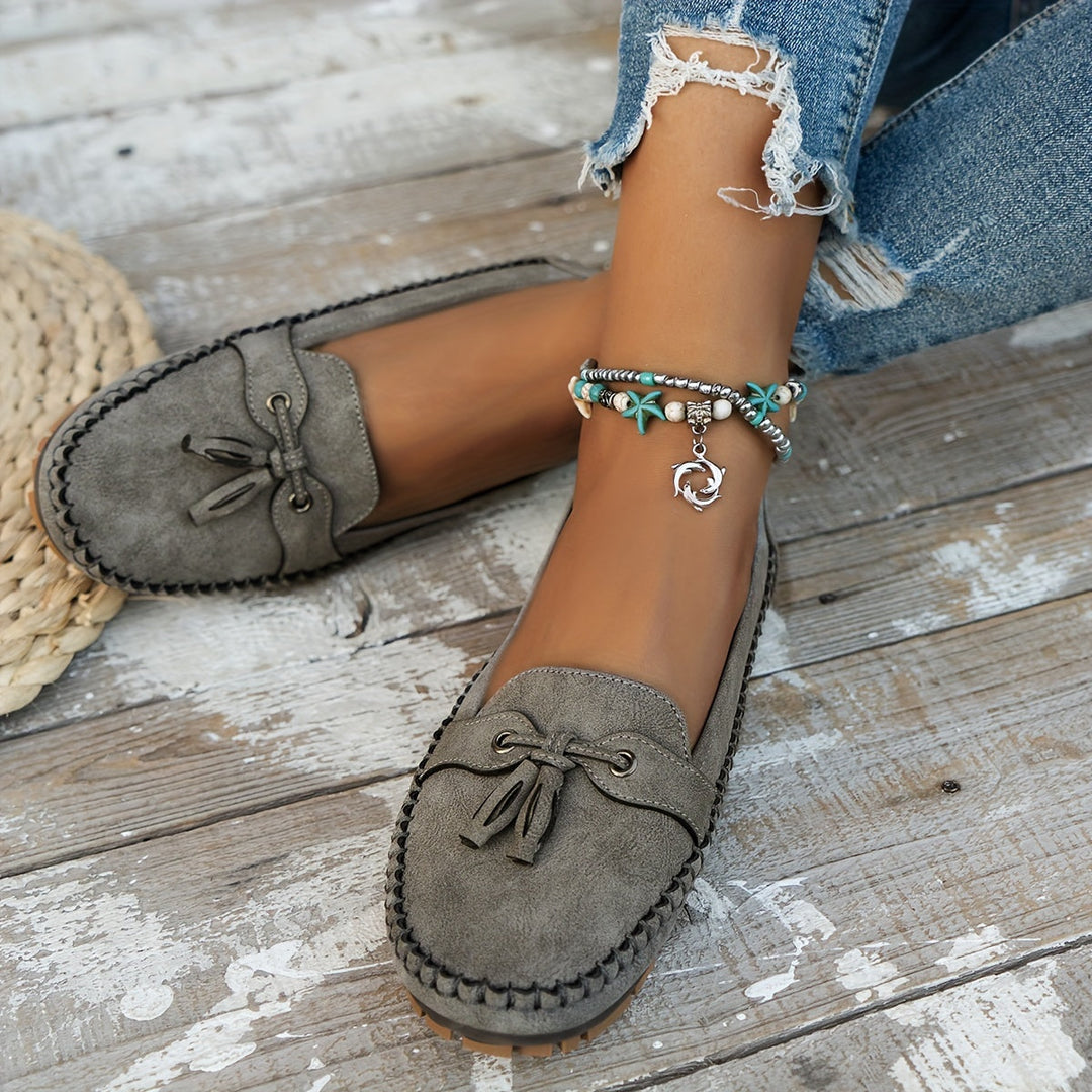 Women's slip-on tassel loafers with moccasin stitching and flat textured soles