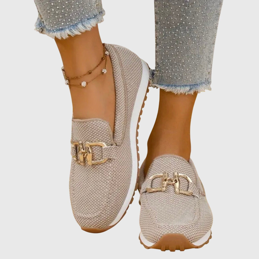 Women's textured slip-on sneakers with metallic buckle detail and flat ridged soles